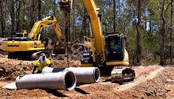 Excavator Laying Pipe